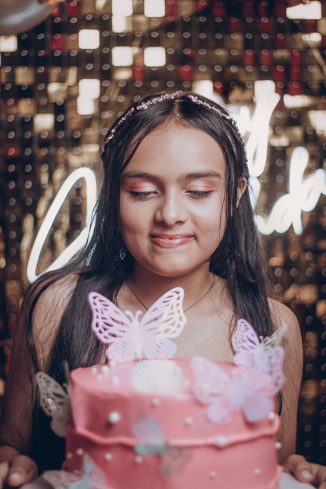 Girl with a pink butterfly birthday cake